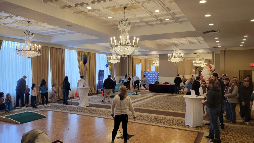 A wide view of the Golf Event with many people socializing