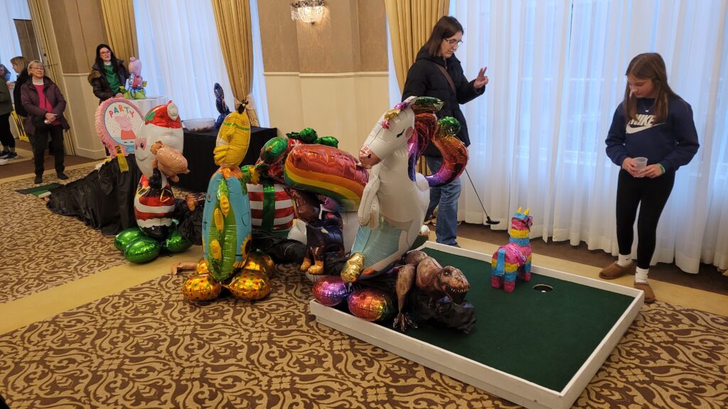 A fun golf course with balloons and pinatas as obstacles.