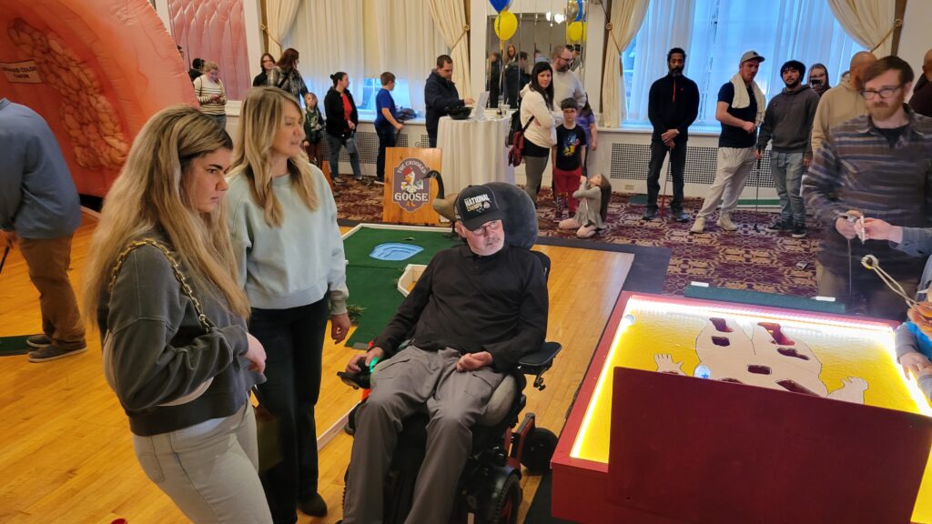 A man in a wheelchair watching a large game of operation
