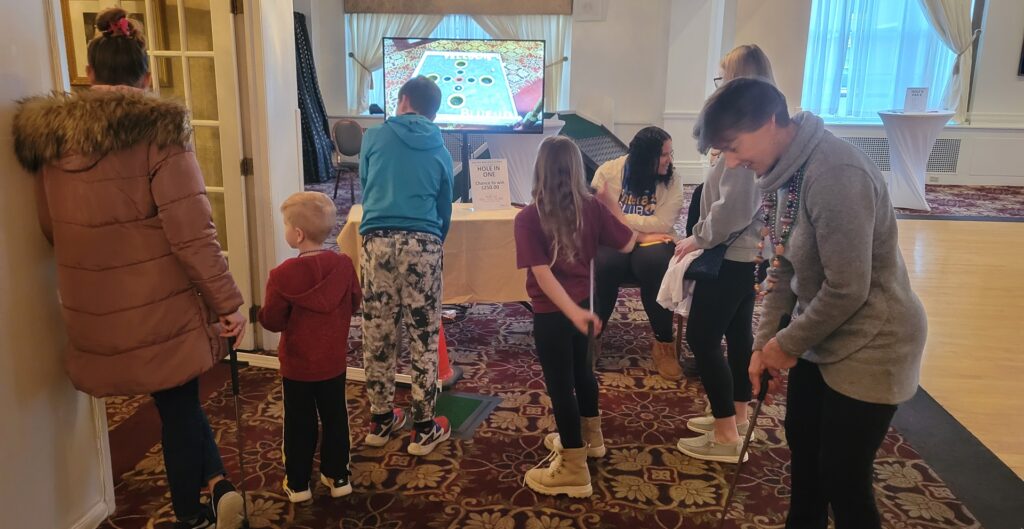 People gathered around a virtual golf course