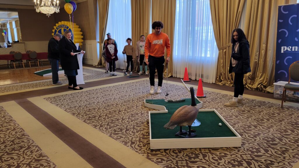 People watching someone golf on a goose golf course